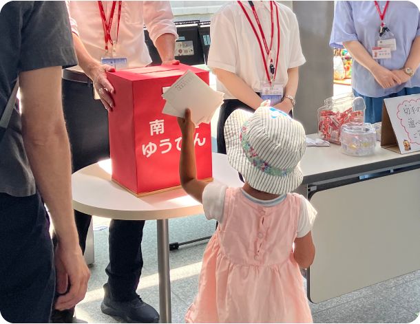 南極ゆうびんのポストにハガキを入れる参加者の画像
